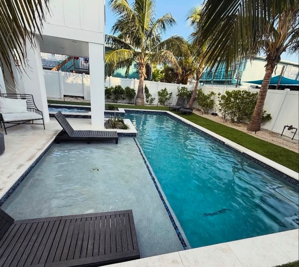 GPM2 luxury pool renovation with custom tanning shelf and travertine coping