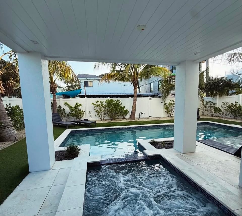 Integrated jacuzzi spa with jet system, white columns and palm backdrop